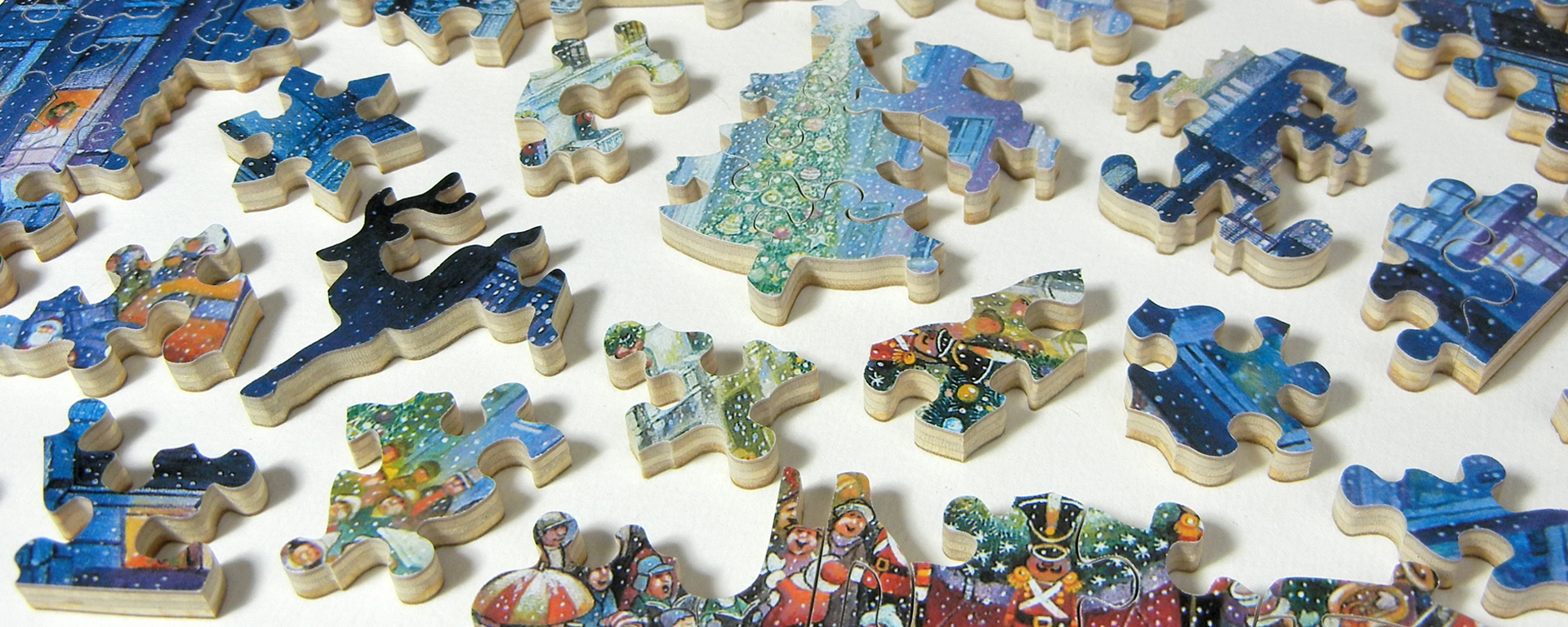 Wooden jigsaw Christmas puzzle featuring puzzle pieces in classic Christmas shapes such as reindeers, snowflakes, and Christmas trees.